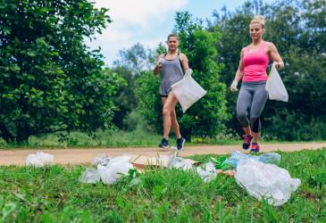 Twee vrouwen in jog-outfit rapen afval op