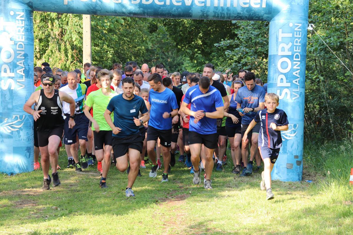 Een grote groep lopers komen aan bij de finish