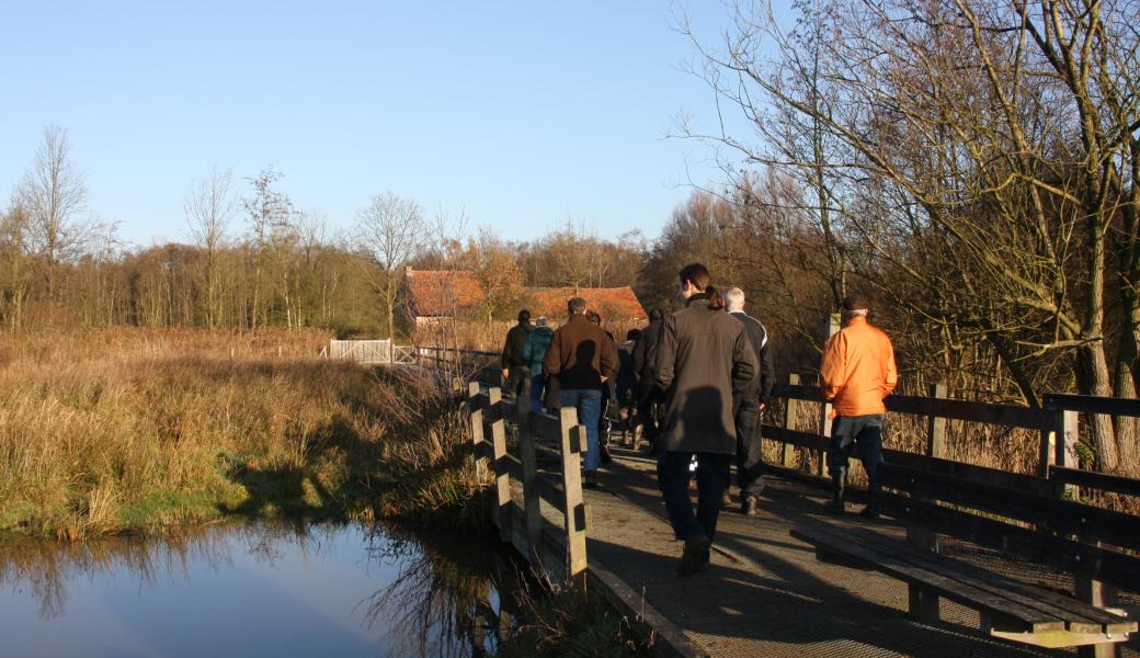 wandelaars op een brugje over het water