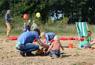 Spelende kinderen in de zandspeelzone van het Parkbos