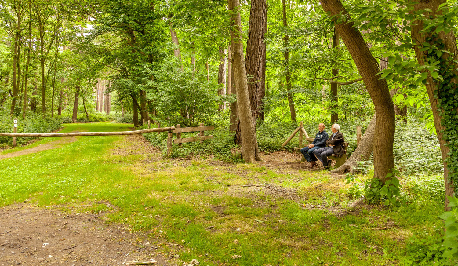 2 wandelaars op een bank in het bos